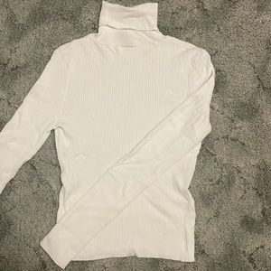 White, long sleeve, turtle neck, textured lines, tight fit.